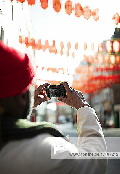Male tourist with digital camera on city street