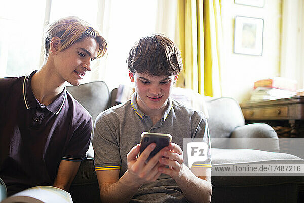 Teenager-Jungen benutzen ein Smartphone im Wohnzimmer