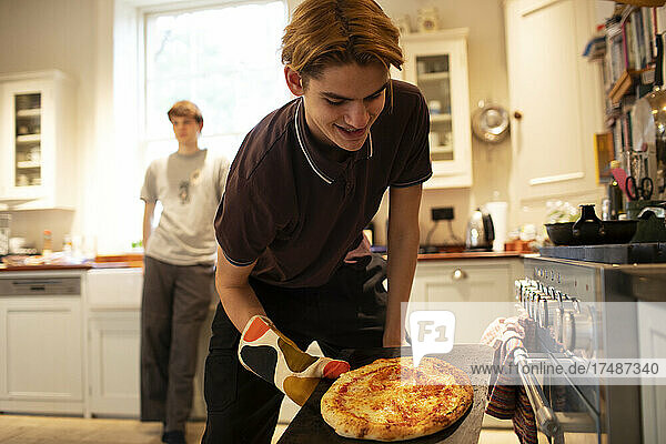 Jugendlicher beim Pizzabacken in der Küche