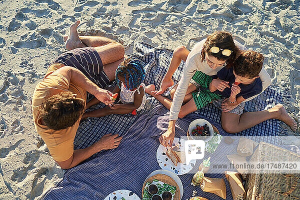 Familie genießt Picknick-Mittagessen am Sommerstrand