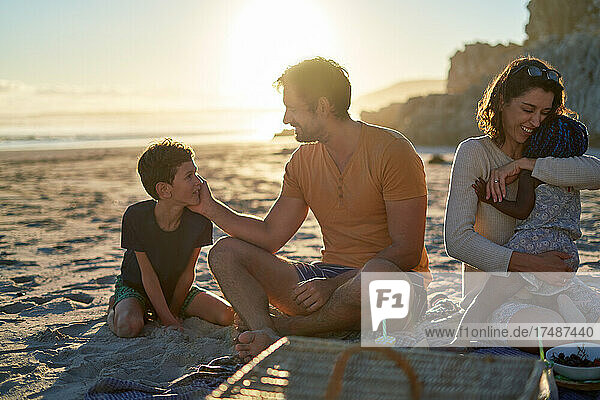 Happy family enjoying picnic on summer beach