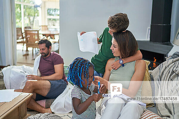 Familie liest und malt im Wohnzimmer