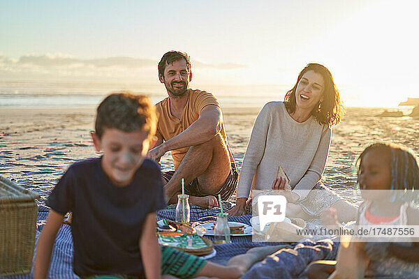 Happy family enjoying picnic on sunny beach