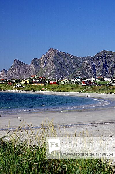 Langgezogener Sandstrand  Häuser und hohe Berge  Ramberg  Flakstadøya  Flakstad  Lofoten  Nordland  Norwegen  Europa