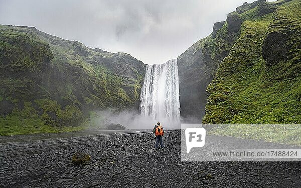 Hikers in front of Skógafoss waterfall  South Iceland  Iceland  Europe