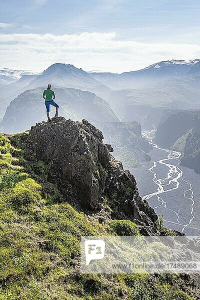 Wanderin blickt über Landschaft  Berge und Gletscherfluss in einem Bergtal  wilde Natur  hinten Gletscher Eyjafjallajökull  Isländisches Hochland  Þórsmörk  Suðurland  Island  Europa