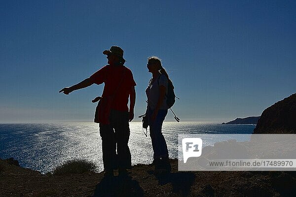 Hikers on cliff in backlight  man and woman hiking by the sea  Cabo de Gata  Andalucia  Spain  Europe