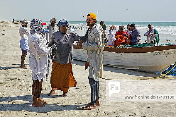 Fishermen hauling in nets on the beach  Salalah  Salalah  Dhofar  Oman  Asia