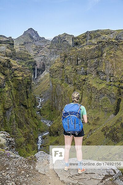 Hiker in front of mountain landscape with canyon  river in Múlagljúfur Canyon  Sudurland  Iceland  Europe