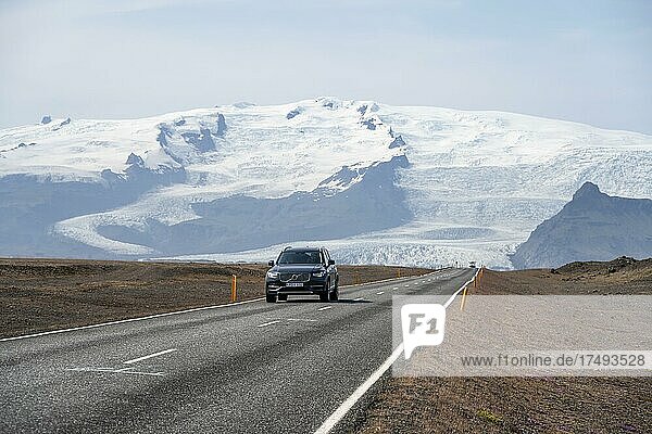 Car on country road  huge Vatnajökull glacier behind  ring road  Iceland  Europe