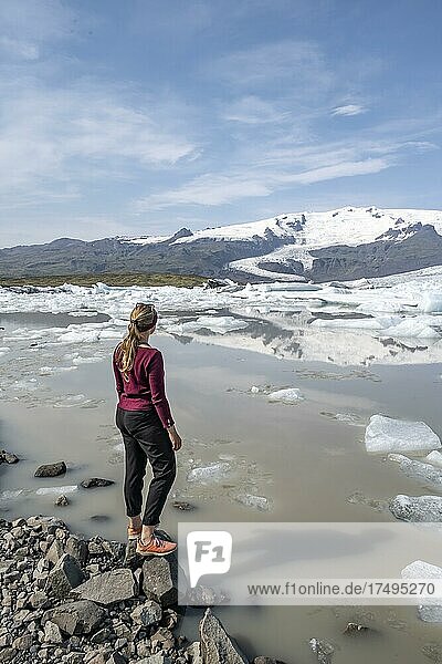 Woman standing in front of Fjallsárlón ice lagoon  ice floes in front of Vatnajökull glacier  Hornafjörður  Iceland  Europe