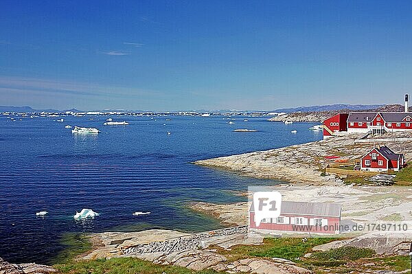 Wohnhäuser und das Ortskrankenhaus  Strand  mit Eisbergen bedeckte Bucht  Ilulissat  Arktis  Diskobucht  Grönland  Arktis  Dänemark  Nordamerika