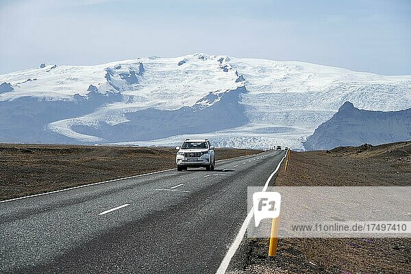 Car on country road  huge Vatnajökull glacier behind  ring road  Iceland  Europe