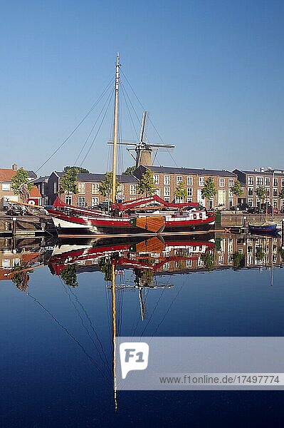 Alte Schiffe  Mühle und Häuser spiegeln sich im Hafenbecken  Morgenstimmung  Hellevoetsluis  Südholland  Niederlande  Europa