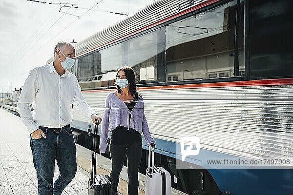 Touristen mit Koffern und Masken auf dem Bahnsteig neben dem Zug  Portugal  Europa