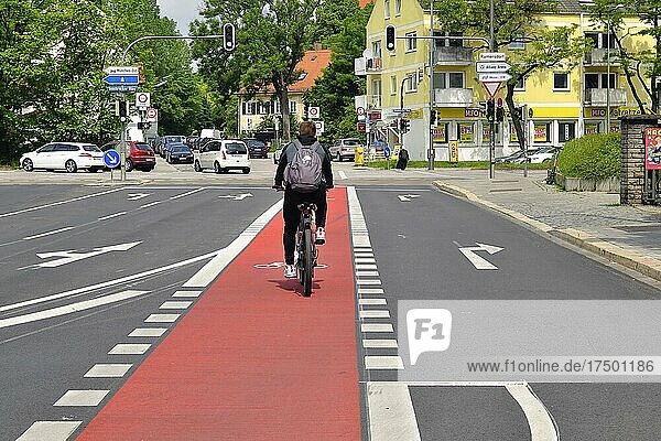 Radfahrer auf rotem Fahrradweg zwischen den Autospuren  München  Bayern  Deutschland  Europa