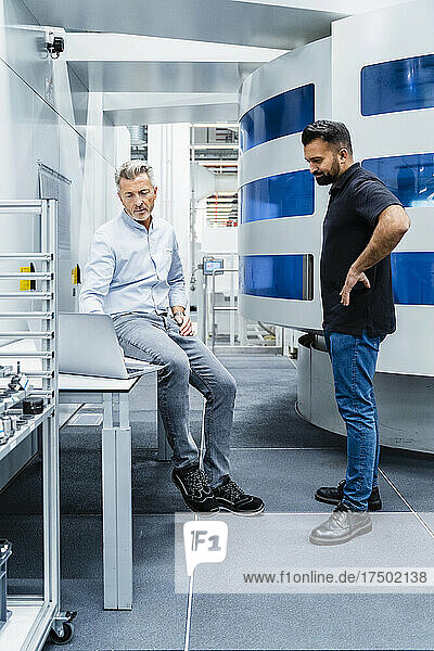 Engineer having discussion with businessman at automated electrical industry