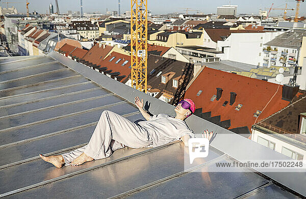 Frau mit Augenmaske sonnt sich auf dem Dach