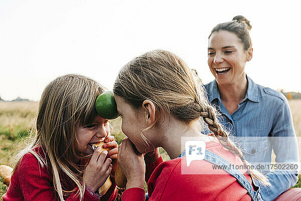 Verspielte Mädchen  die Obst in der Hand halten und Brot im Park essen