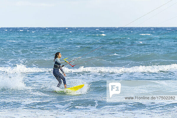 Woman kiteboarding on water
