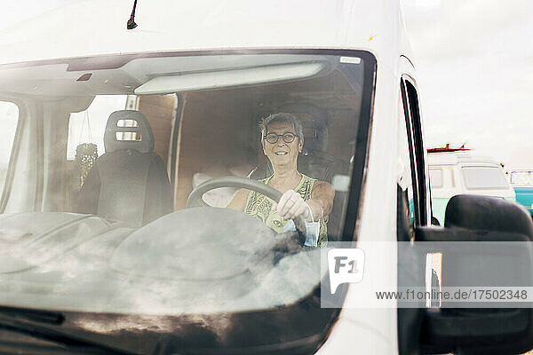 Smiling woman driving camper trailer
