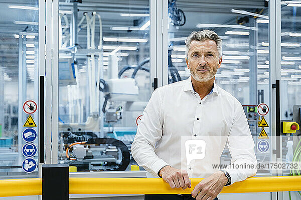 Businessman standing at automated factory