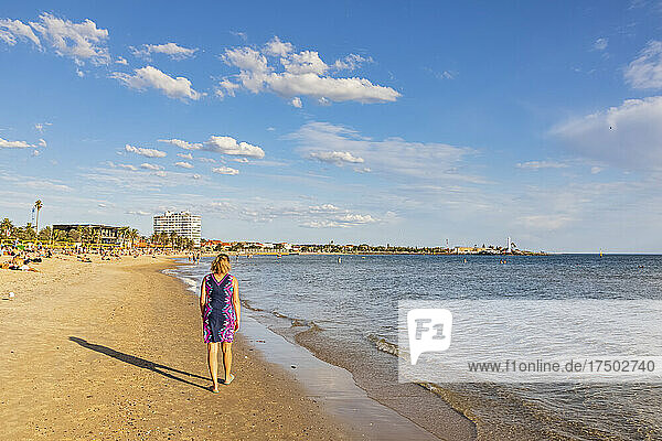 Australia  Victoria  Melbourne  Female tourist walking along Saint Kilda Beach in summer