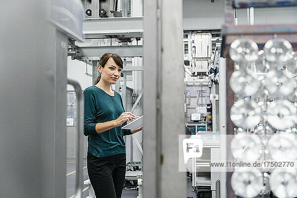 Businesswoman with tablet PC at automated electrical industry