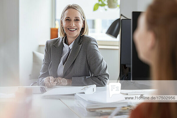 Smiling senior businesswoman at office desk