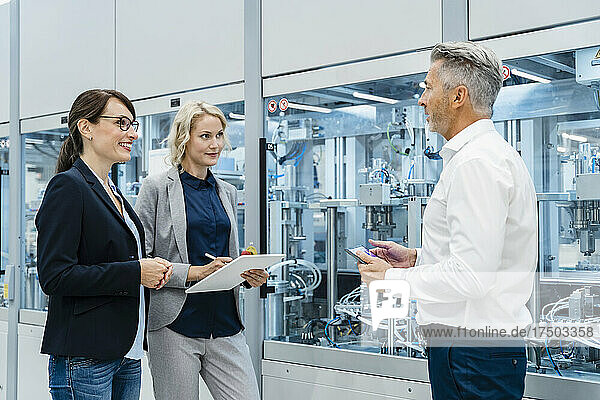 Businessman discussing with coworkers at automated industry