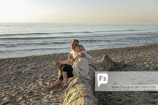 Man with woman enjoying sunset at beach