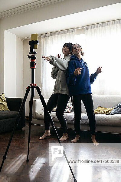 Friends filming dance through mobile phone at home