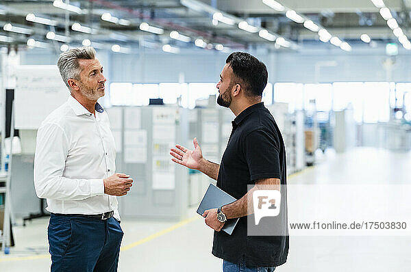 Businessman having discussion with engineer at automated industry