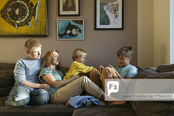 Family sitting on sofa at home