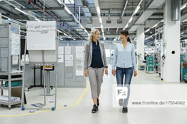 Businesswomen discussing and walking in electrical industry