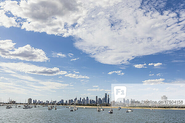 Australia  Victoria  Melbourne  Clouds over coastal city with boats floating in foreground