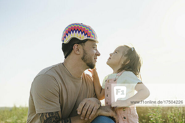 Girl looking at father wearing helmet