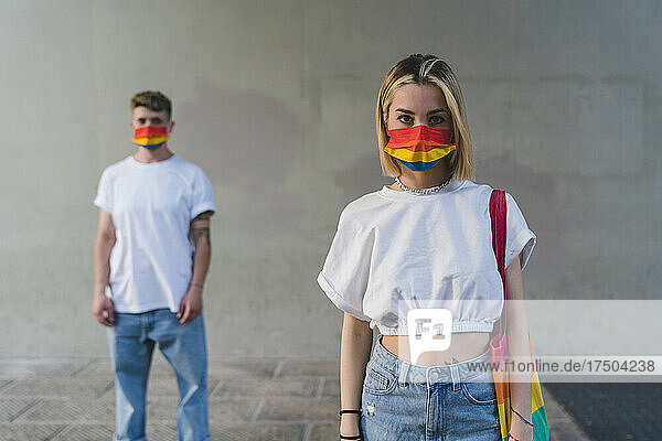 Couple with face mask standing in front of wall