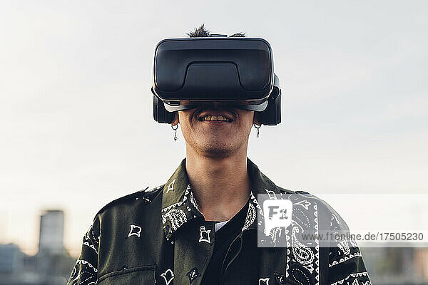 Lächelnder Mann mit Virtual-Reality-Headset in der Stadt