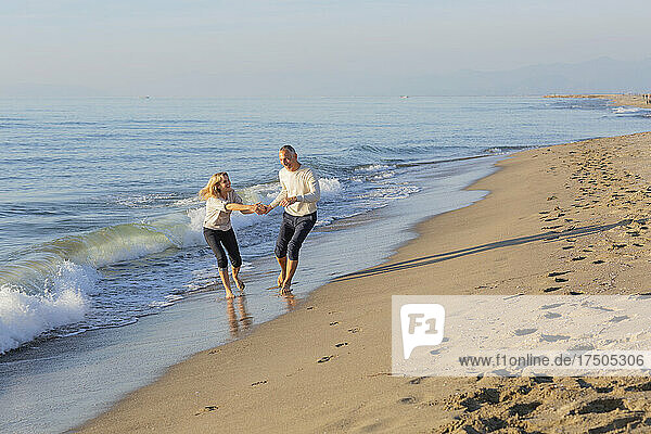 Couple playing together on shore at beach