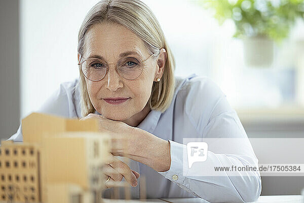 Businesswoman with eyeglasses looking at model in office