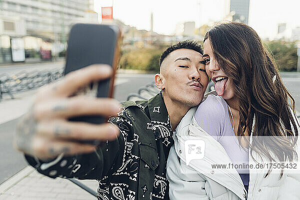 Happy couple taking selfie through smart phone