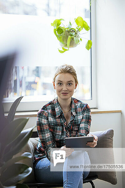 Young businesswoman with tablet PC at office