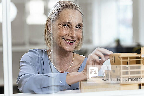Senior female architect with model in office