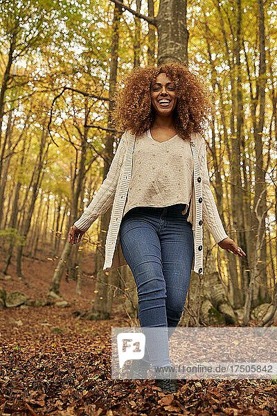 Happy young woman enjoying weekend in autumn forest