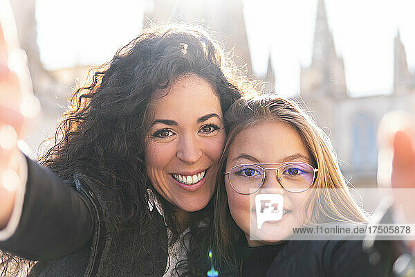 Smiling mother and daughter taking selfie