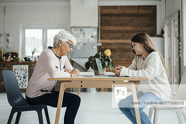 Enkelin und Großmutter sitzen am Tisch