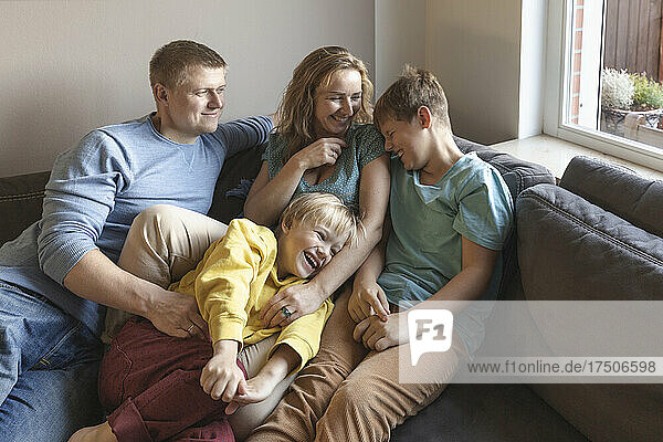 Man looking at family laughing on sofa