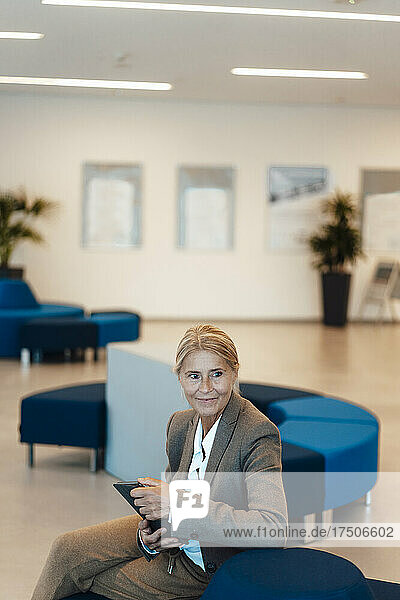 Businesswoman with table PC sitting in office