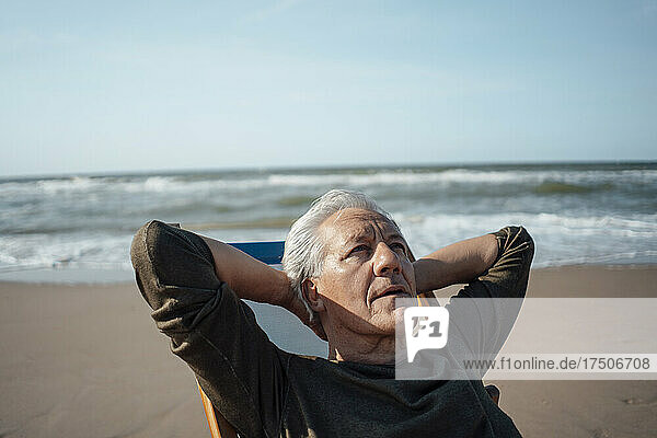 Älterer Mann entspannt sich an einem sonnigen Tag am Strand